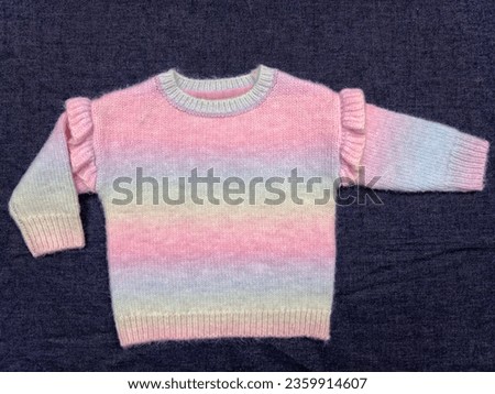 knitted rainbow coloured frill and jumper. Royalty-Free Stock Photo #2359914607