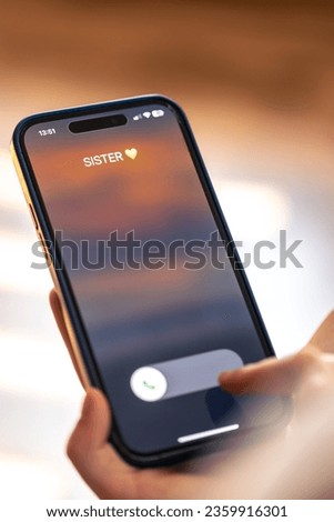 Smartphone in child hands with Incoming sister call on a screen. Royalty-Free Stock Photo #2359916301