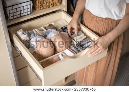 An unidentified neat housewife takes underwear, socks, panties and a bra from a closet drawer. The concept of organization, storage and order. Japanese storage method.