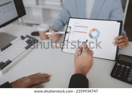 Two people looking at datasheets of marketing and sales results, analysis of business results jointly between executives, department heads and employees to brainstorm company sales management. Royalty-Free Stock Photo #2359934747