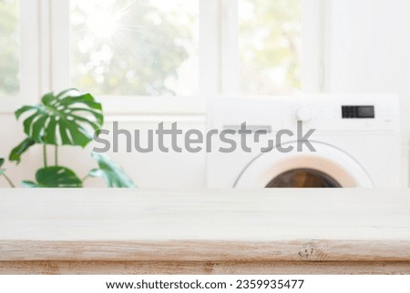 Table space for product montage on blurred washing machine background Royalty-Free Stock Photo #2359935477