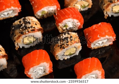 Traditional sushi rolls on black background. Japanese food