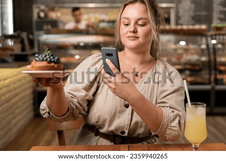 Influencer and also blogger using smartphone to take a photo of brownie before eating breakfast in the cafe. Copy space