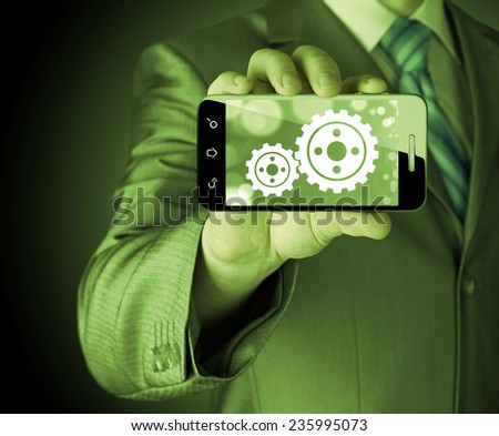 businessman show gear on smartphone to success concept