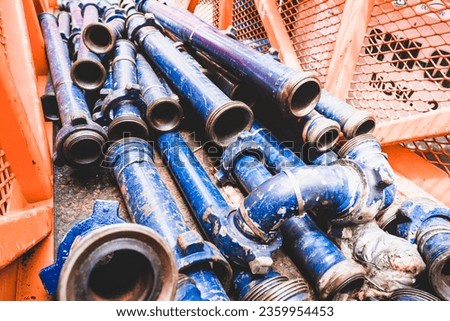Couplings and pipes used in oil and gas drilling are dismantled and ready for use on steel baskets.

