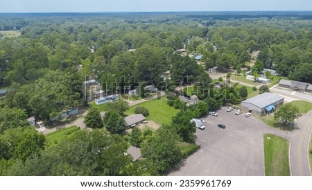 Row of manufactured, modular, and mobile homes surrounding by lush green trees in Richland, Rankin County, Mississippi suburb of Jackson, USA established neighborhood. Aerial view affordable housing