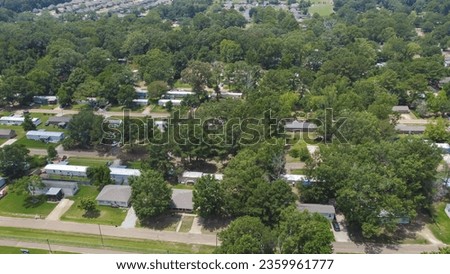 Prefab houses, manufactured, modular, and mobile homes with row of new development single family homes in distance background Richland, Rankin County, Mississippi, USA. Aerial view affordable housing