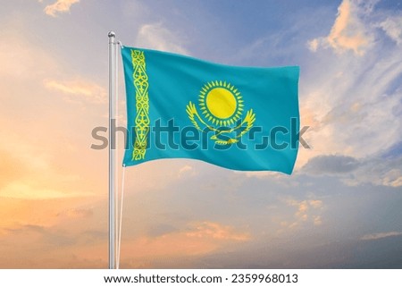 Kazakhstan flag waving on sundown sky Royalty-Free Stock Photo #2359968013