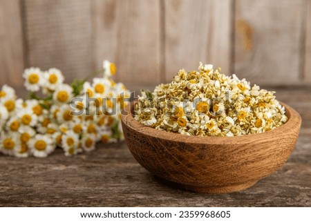 Dry chamomile flowers on a wooden table. Soothing chamomile tea. Herbal drink. flat layout. Space for text.Copy space.Medical prevention and immune concept. Folk alternative medicine. Royalty-Free Stock Photo #2359968605