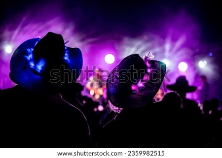 Cowboy Hats Lit Up at Music Festival Royalty-Free Stock Photo #2359982515