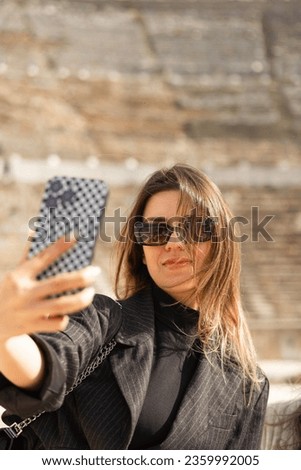 Young woman taking selfie with Ephesus city view. She travels  alone. Self photo. 