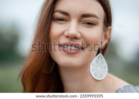 The smile of a young and beautiful girl with braces on her white teeth. Straightening of crooked teeth with the help of a bracket system. Malocclusion. Dental care. Smooth teeth and a beautiful smile Royalty-Free Stock Photo #2359995595