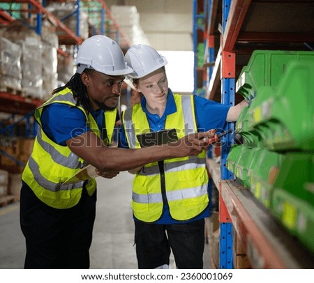Multiracial manager train female technician working job in warehouse and logistic professional occupation. Storehouse supervisor and woman team talking discussing inventory storage or order delivering Royalty-Free Stock Photo #2360001069