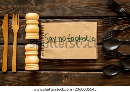 Eco friendly wooden and harmful plastic cutlery with Say no to plastic sign. Zero waste concept.