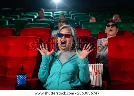 Old woman shocked with scary movie in theater and enjoy her holiday with 3d glass