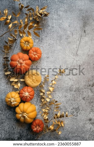 pumpkin shape candles, amulet of moon and dry decorative eucalyptus twigs on abstract grey background. Witchcraft. esoteric spiritual ritual for mabon, halloween, samhain sabbat. top view. copy space Royalty-Free Stock Photo #2360055887
