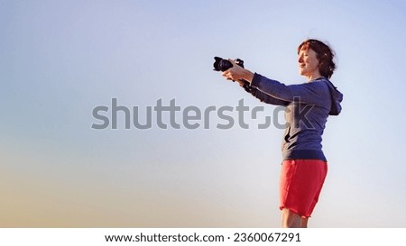 Tourist woman with camera taking travel photo outdoor on nature