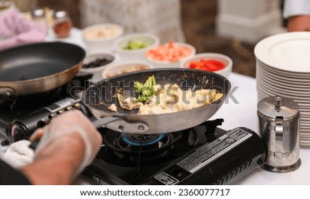 Sizzling culinary artistry in a hot frypan, epitomizing the joy and creativity of home cooking Royalty-Free Stock Photo #2360077717