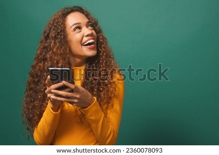 Beautiful young woman looks to copy space right, excited, sale, green studio Royalty-Free Stock Photo #2360078093