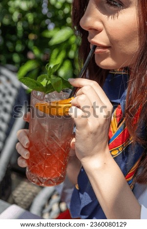 Beautiful young woman drinking cocktail alone in the morning