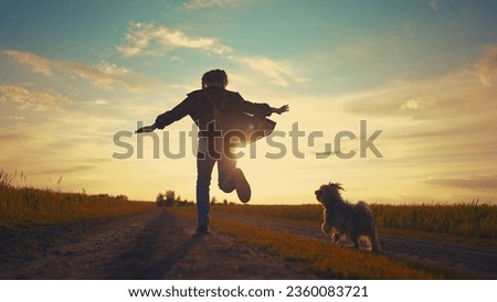teen girl running with dog in the park. happy family freedom a kid dream concept. silhouette of a teenage girl running along the road in the park at sunset view from the back sun with a shaggy dog Royalty-Free Stock Photo #2360083721