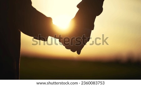 father holding her son hands. happy family kid dream concept. father take care her daughter holding her hands at sunset in the park close-up. hands close-up parent and lifestyle daughter Royalty-Free Stock Photo #2360083753