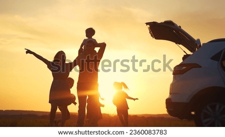 family by car resting in the park. family and children silhouette resting on the car playing ball at sunset in park on vacation. happy family kid dream concept. camping by sun car in the park