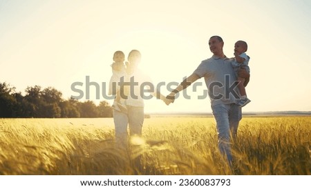 happy family in park wheat field. friendly family walks in wheat field with two children baby toddlers in summer. happy family kid dream concept. big sunlight family silhouette in wheat field