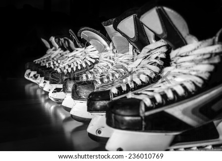 Pairs of hockey skates lined up in a locker room