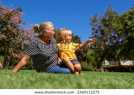 grandmother and grandson are walking in the park on a summer day