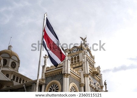 Beautiful View of the Costa Rica Flag with the Bicentennial Angel in Cartago, next to the Ruins and the basilica - Costa Rica Patriotic Symbols Royalty-Free Stock Photo #2360115121