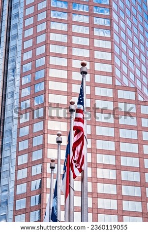 American flag in front of a skyscraper.