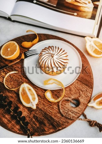 Lemon tart with merengue sweet dessert over white marble table in cafe. French cuisine, comfort food, fine dining concept