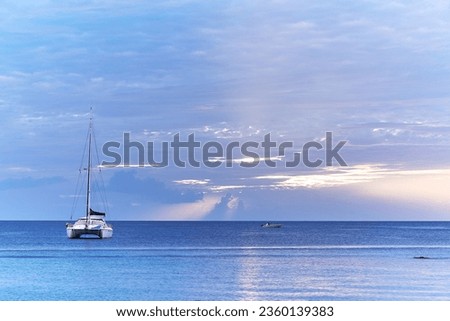 A catamaran anchored in the Caribbean Sea at sunset off the island of Martinique