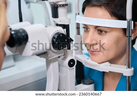 Adult woman undergoing biomicroscopy procedure at ophthalmology office Royalty-Free Stock Photo #2360140667