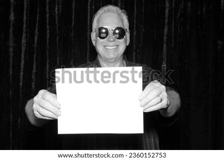 Photo Booth. A smiles as he holds a blank white sign while having his pictures taken in a Photo Booth. Blank Sign. Room for text or images. Photo Booth Sign. Wedding Photo Booth. Party Time. 