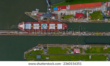 Panama Canal area view, container ship transit, water tanks, composed of locks Royalty-Free Stock Photo #2360156351