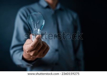 lamp, light bulb, close up, hand, businessman, portrait, background, blue, hold, ideas. picture is close up to businessman, him hold light bulb. wait for best ideas and creates from other to light up.