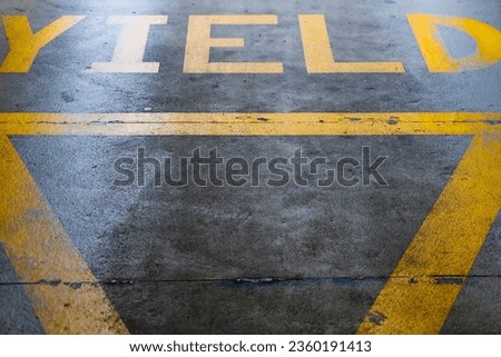 Worn yellow yield sign at the exit of a car park near Tallaght Square