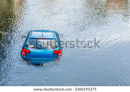Blue car drown in water canal. Extreme accident vehicle sink in river pound lake, traffic incident Royalty-Free Stock Photo #2360195375