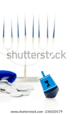 Blue dreidel with silver tokens on a white background