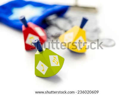 Colorful dreidels with silver tokens on a white background