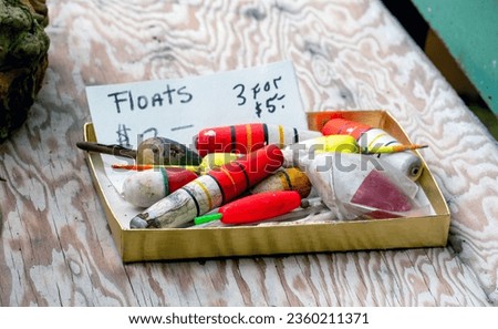 Box of fishing floats is for sale at an outdoor yard sale, great deals for an avid fisherman