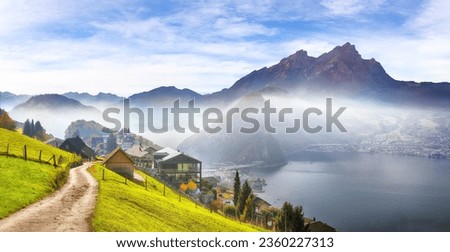 Gorgeous autumn view on suburb of Stansstad city and Lucerne lake with mountaines and fog. Poppular travel destination in Swiss Alps.   Location: Stansstad, Canton of Nidwalden, Switzerland, Europe