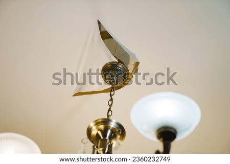 A torn stretch ceiling with a ceiling lamp mount is a problem in the interior Royalty-Free Stock Photo #2360232749
