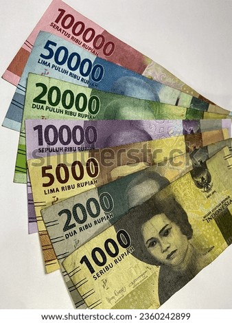 Close-up photo of Indonesian Rupiah banknotes, on a white background