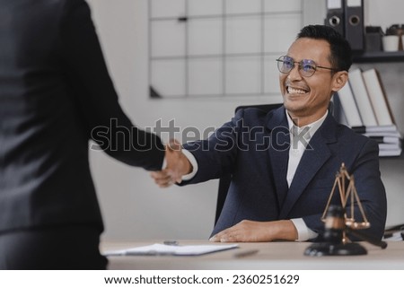 Lawyer meeting contact us concept: Lawyer and business people shaking hands at desk in office, justice and law, attorney.