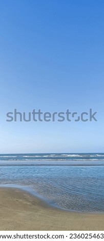 a stretch of white sand beach with a beautiful blue sky at Lombang Beach, Sumenep, East Java
