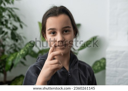 Beautiful smiling deaf girl using sign language.