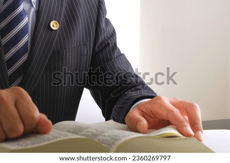 A male lawyer who reads all the six laws.

On the cover of the book, it is written as "Rokuho Zensho" in Japanese. Royalty-Free Stock Photo #2360269797